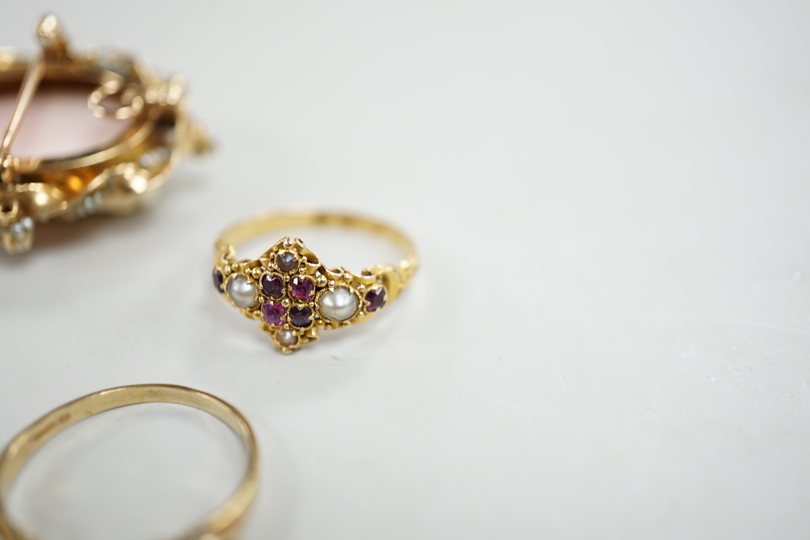 A late Victorian 15ct gold, black enamel and seed pearl set mourning ring, with glazed panel below, size L, one other Victorian 18ct gold, garnet and seed pearl set ring, with engraved initials, two modern 9ct gold and g